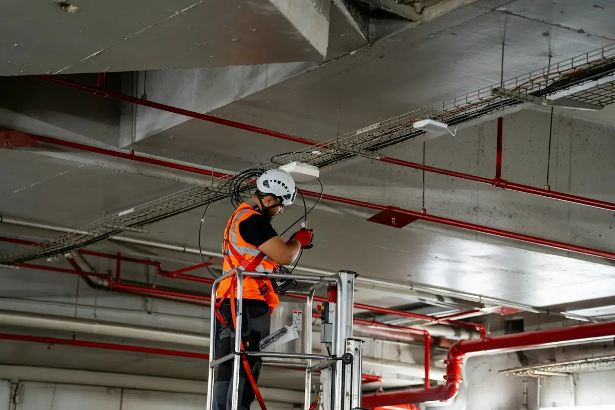 Technician on a lift installing equipment on a garage ceiling