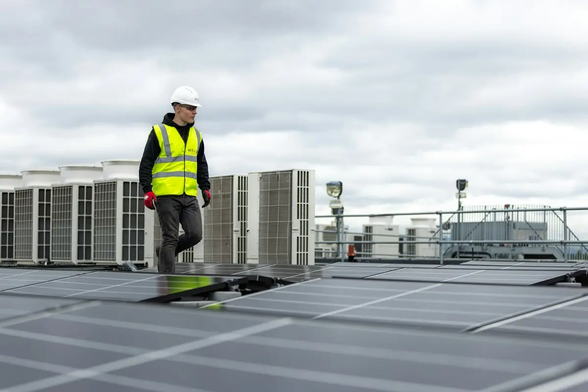 Technician walking between rooftop HVAC units on a commercial building