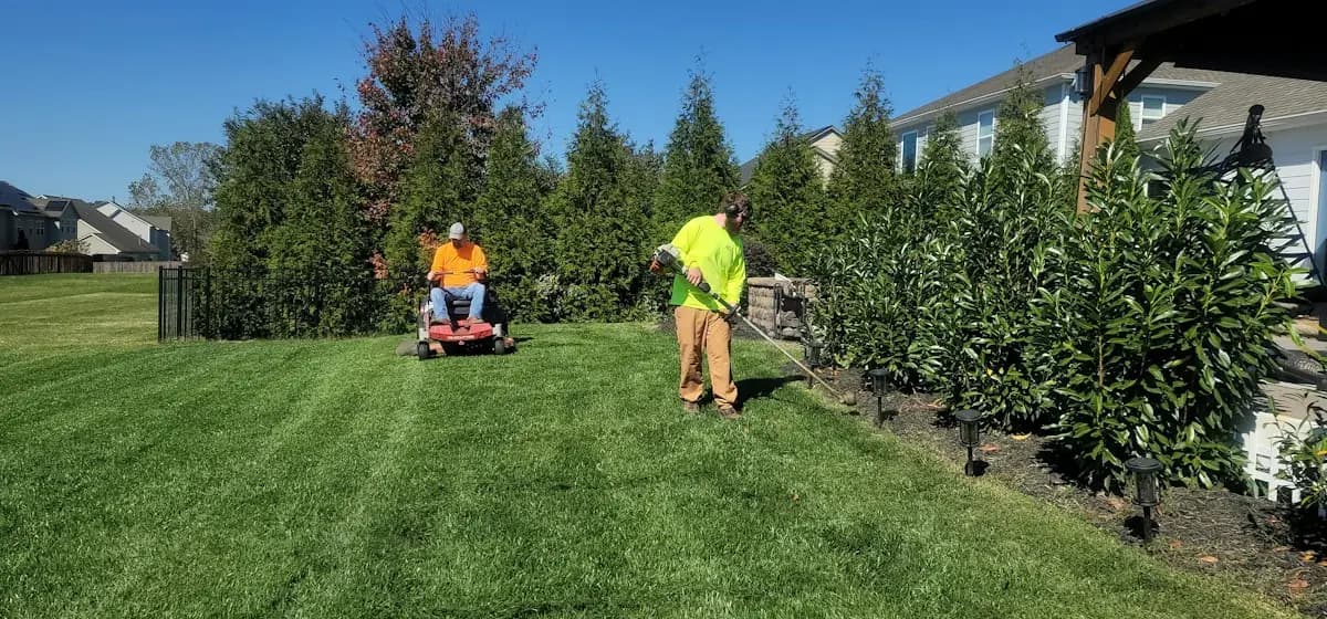 Grounds crew mowing and trimming the lawn at a property