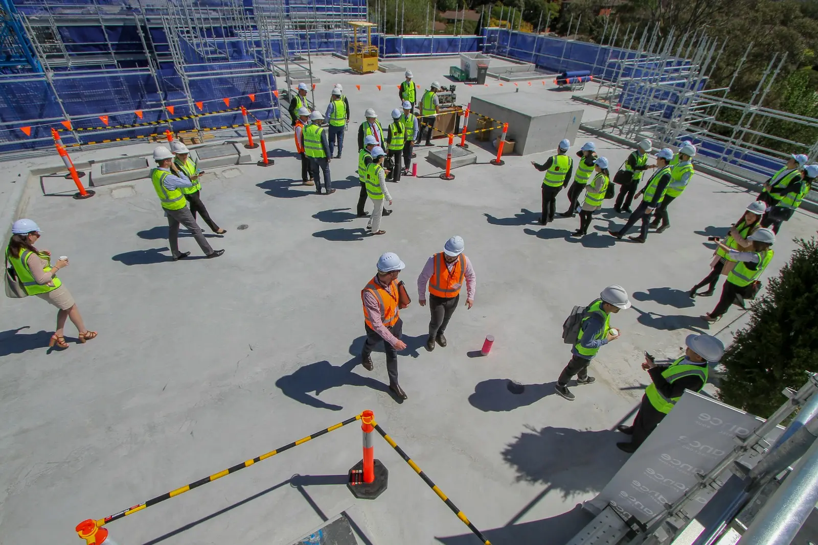 Construction crew in hard hats and hi-vis working on a concrete deck