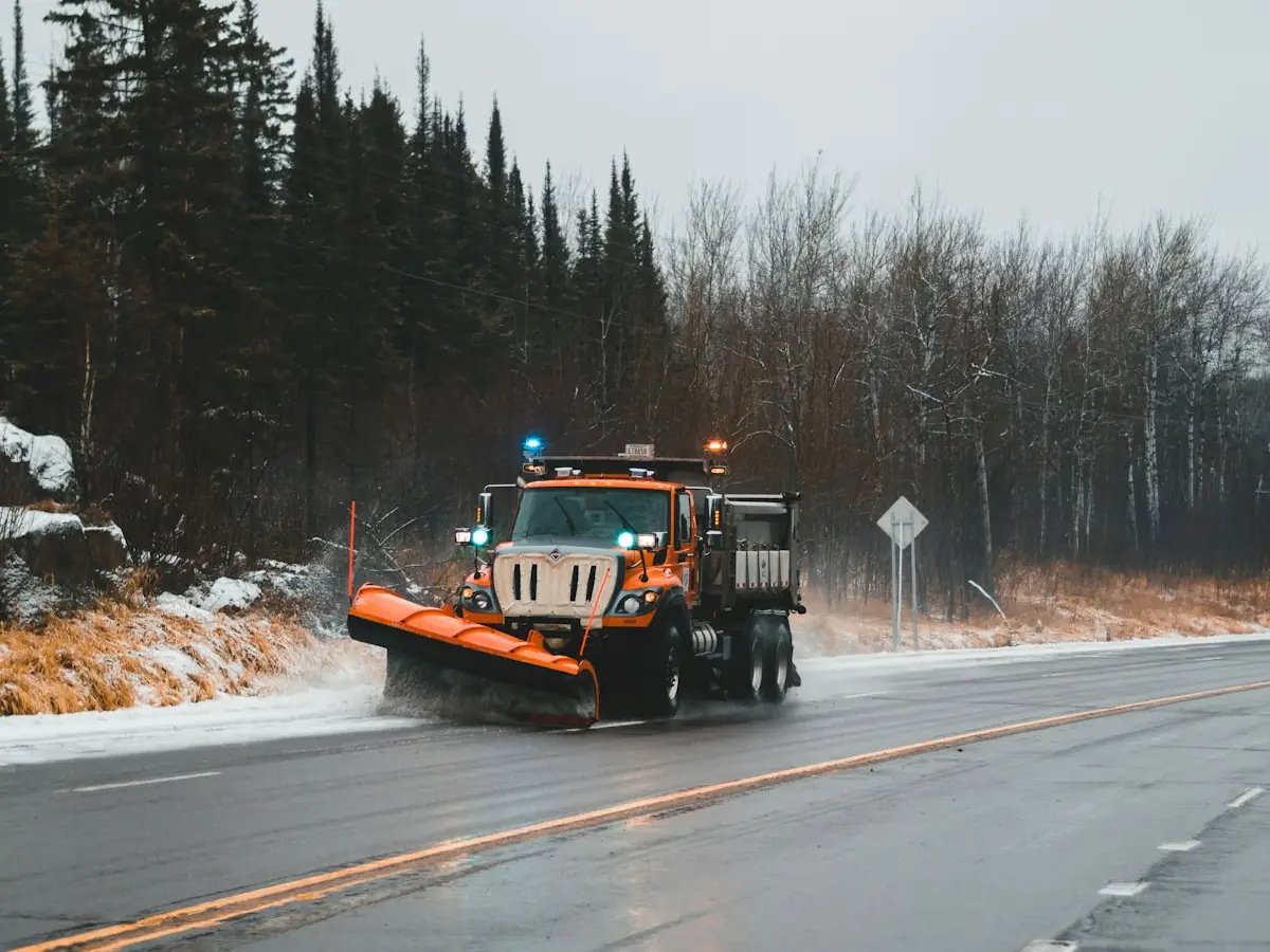 Snow plow truck clearing a road during a winter storm