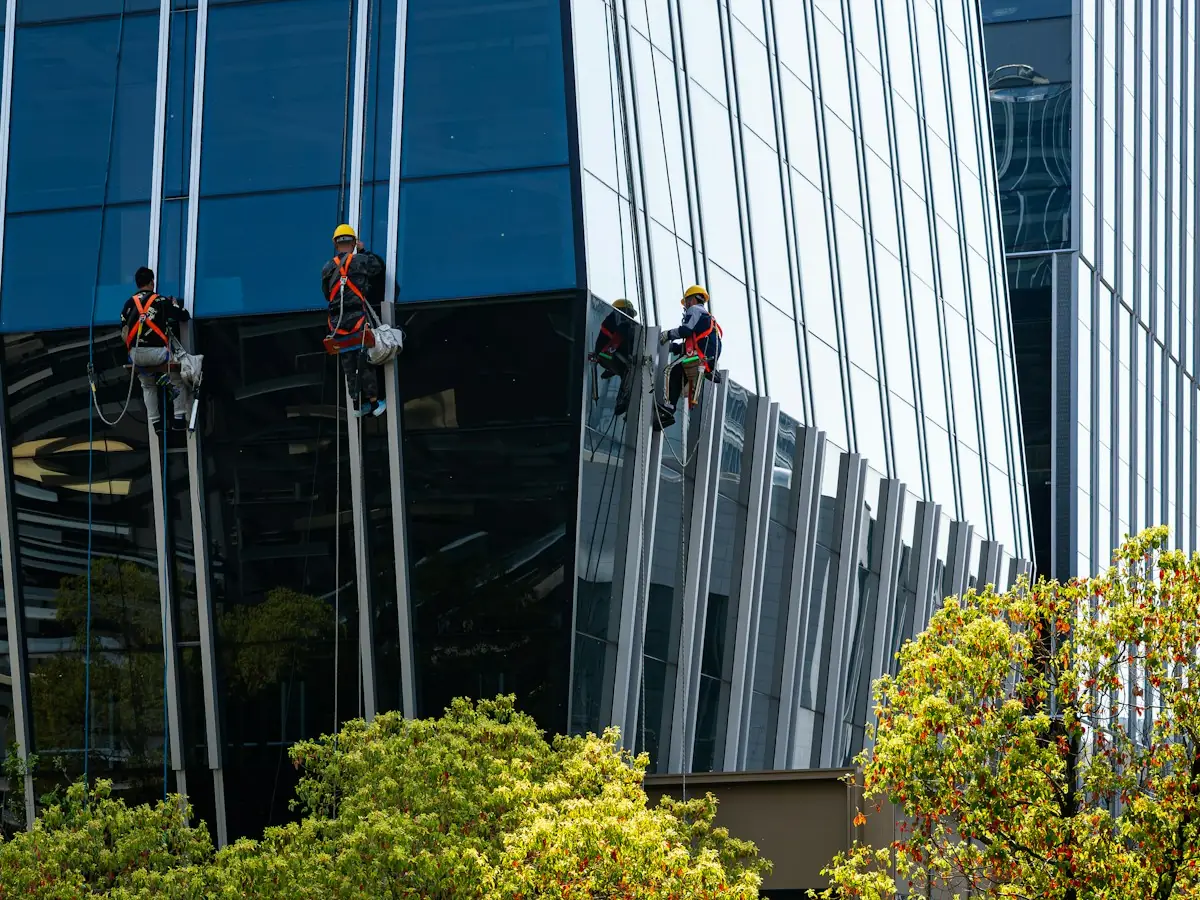 Window cleaners on ropes washing the glass facade of an office tower